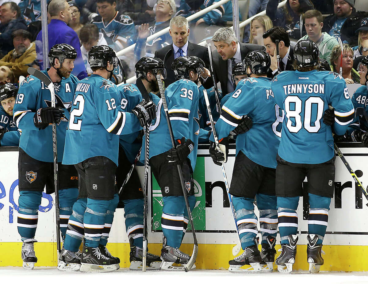 Todd McLellan (center) has seen some rough times for his team, but has the Sharks in playoff position at the break.