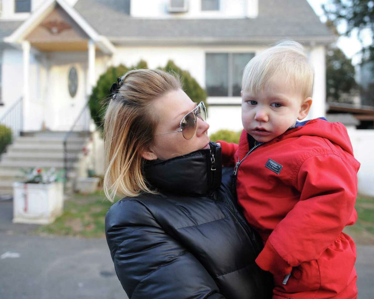 Dawn Fortunato holds her 2-year-old son, Charlie, outside their home near Armstrong Court in the Chickahominy section of Greenwich, Conn. Friday, Jan. 23, 2015. Fortunato believes that there are environmental hazards in her neighborhood, which lies downstream from a former incinerator, that caused her son, Charlie, to get lead poisoning.