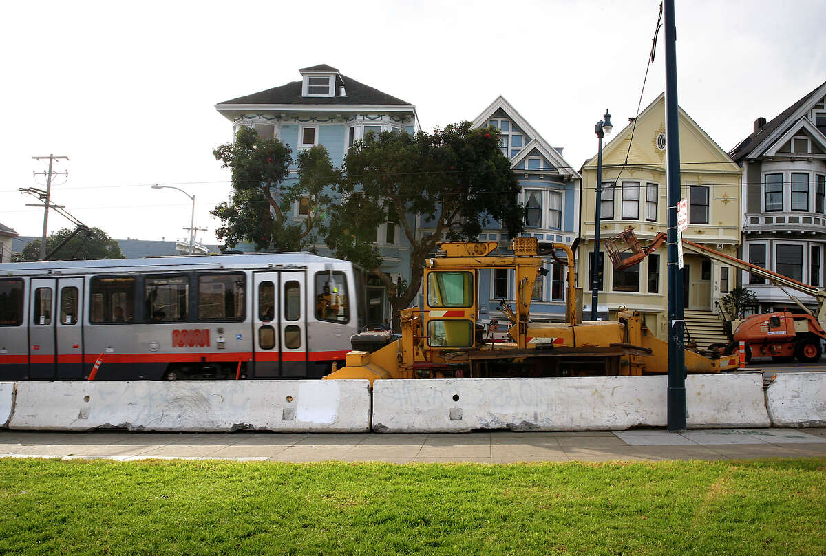 A Muni streetcar passes equipment in San Francisco’s Duboce Park neighborhood being used in construction work going on inside the Sunset Tunnel. The work is designed to improve service on the busy N-Judah Metro line.