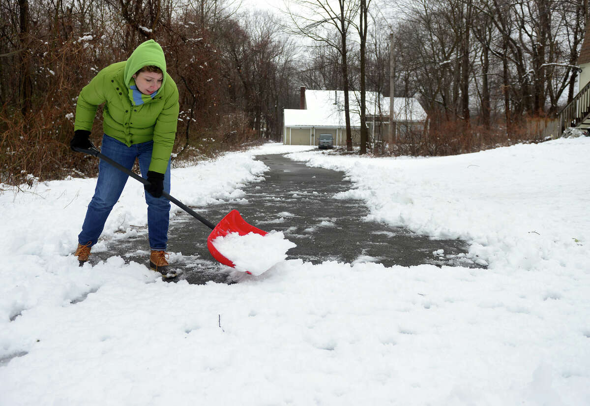 Paula Bajoros shovels the last section of her very long driveway at her home along Shelton Road in Trumbull, Conn. on Saturday Jan. 24, 2015.