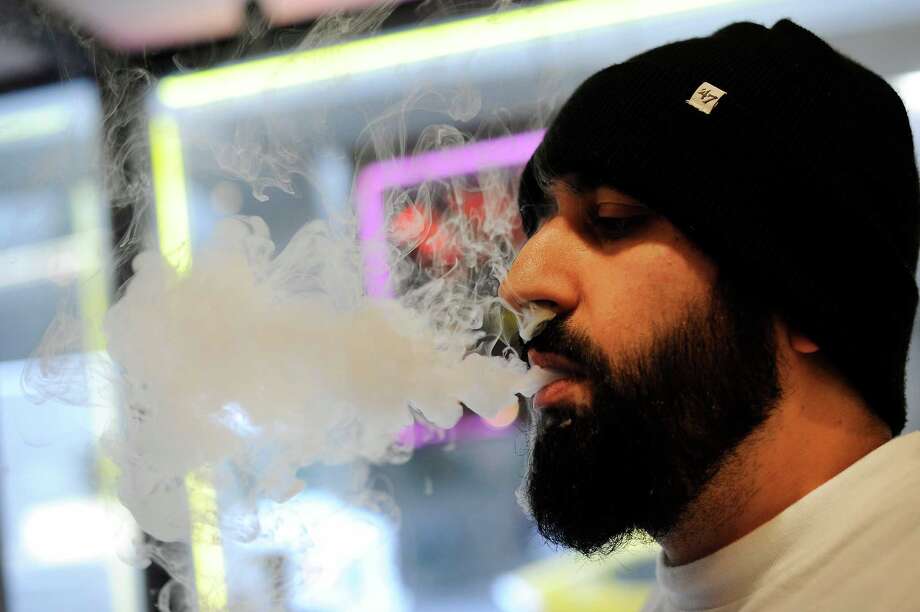 owner feras kalieh smokes his e-cigarette or vaporizer, while