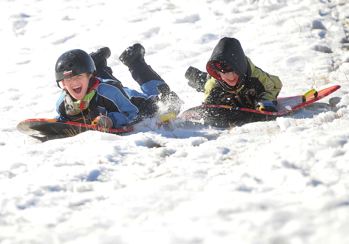 Brothers Michael, 8, left, and Harrison Dorosh, 5, of Oxford, enjoy a ride down the sled hill at Osborndale State Park in Derby, Conn. on Sunday, January 25, 2015.