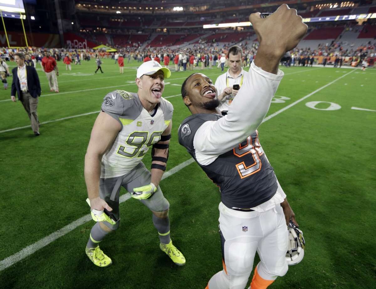 Houston Texans' J.J. Watt (99) poses for a selfie with St. Louis Rams' Robert Quinn after Team Irvin defeated Team Carter 32-28 in the NFL Football Pro Bowl Sunday, Jan. 25, 2015, in Glendale, Ariz. (AP Photo/Mark Humphrey)