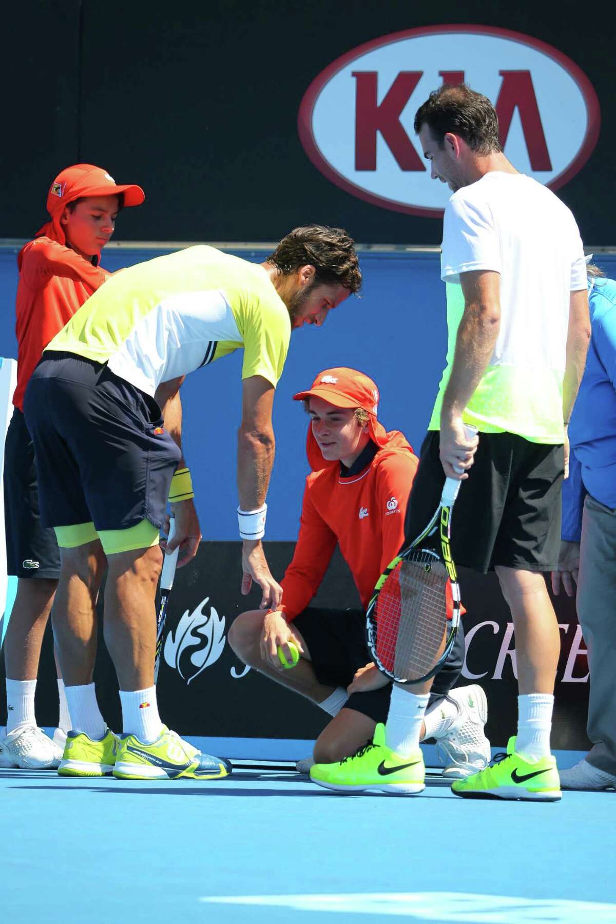 Feliciano Lopez of Spain talks with ball boy Sam Day after striking him with a served ball at the 2015 Australian Open at Melbourne Park.