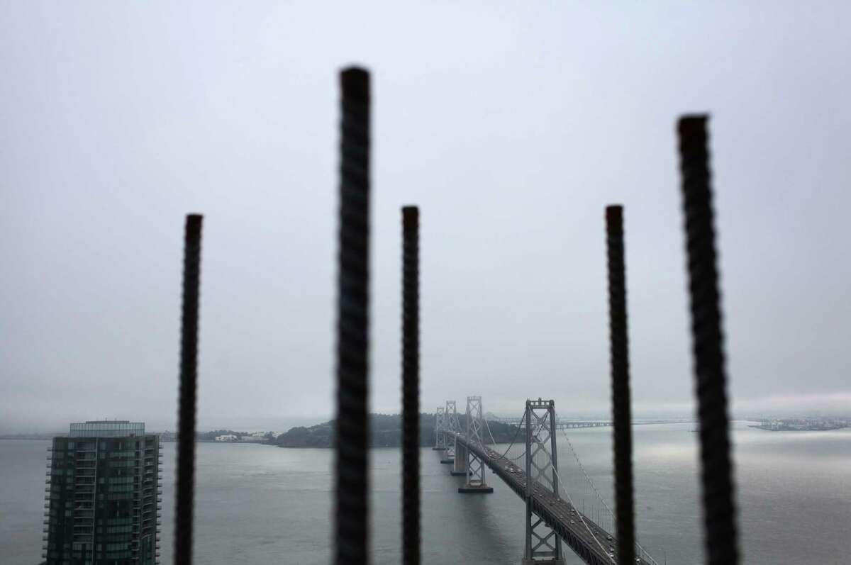 Exposed pieces of rebar frame the Bay Bridge as seen from atop One Rincon Hill Phase Two in San Francisco in 2013.