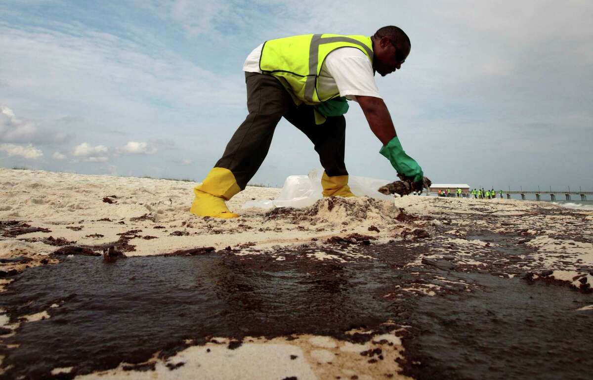 A BP witness in federal court on Monday disputed government testimony that the 2010 oil spill had long-term health effects on clean-up workers like this one in Gulf Shores, Ala. (AP Photo/Dave Martin, File)