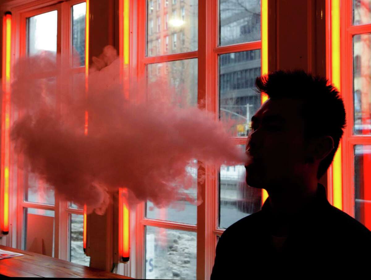 An e-cigarette user exhales vapor. Using certain e-cigarettes at high settings could release much more formaldehyde, a cancer-causing chemical, than smoking traditional cigarettes does, lab tests suggest. The research published in the New England Journal of Medicine on Wednesday, Jan. 21, 2015, is not proof of a risk — it involved limited testing on just one brand of e-cigarettes. But scientists say it shows how little is known about the safety of these popular devices.
