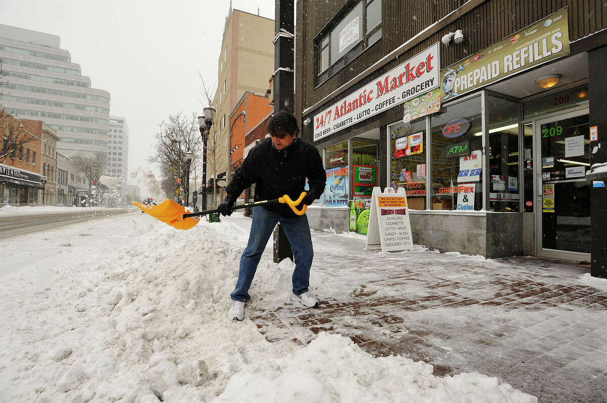 Owner of 24/7 Atlantic Market Sanjay Patel shovels in front of his business in downtown Stamford, Conn., during the snow storm that hit New England on Tuesday, Jan. 27, 2015. He said he expects business to pick back up around 6 p.m.