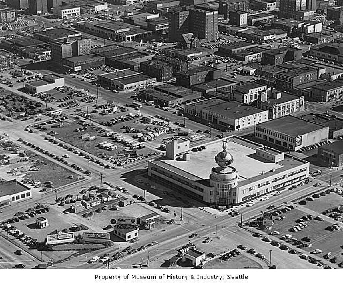 Aerial looking southwest showing Post-Intelligencer building Seattle, 1953 - MOHAI caption: The Seattle Post-Intelligencer started publishing in 1881. In the late 1940s, the newspaper held a nationwide competition for an architect for a new building on Wall Street. The design included a large, revolving globe with an eagle on top, which stood above the entryway. The streamlined style of the building, with its glass and flat surfaces, was very popular during the 1930s and 1940s.