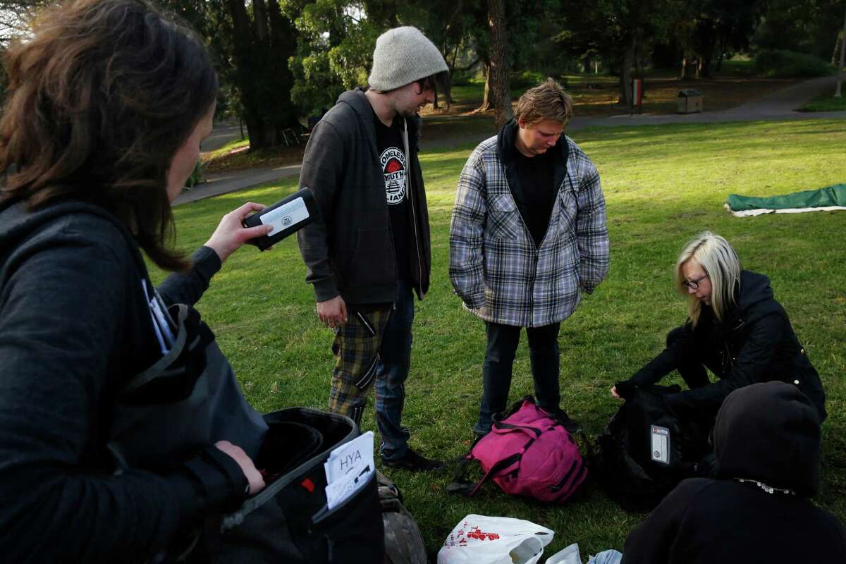 Senior Outreach Counselor Jennifer Cowles (left) and Mary Howe (far right), executive director of the Homeless Youth Alliance, Mary Howe, give out supplies and chat with Valentine, 20 (left), and Tyi, 24, during an outreach session in GoldenGate Park near Haight Street. The alliance lost its lease on its drop-in center on Christmas 2013, and now work out of a garage and the home of a doctor in trhe neighborhood.