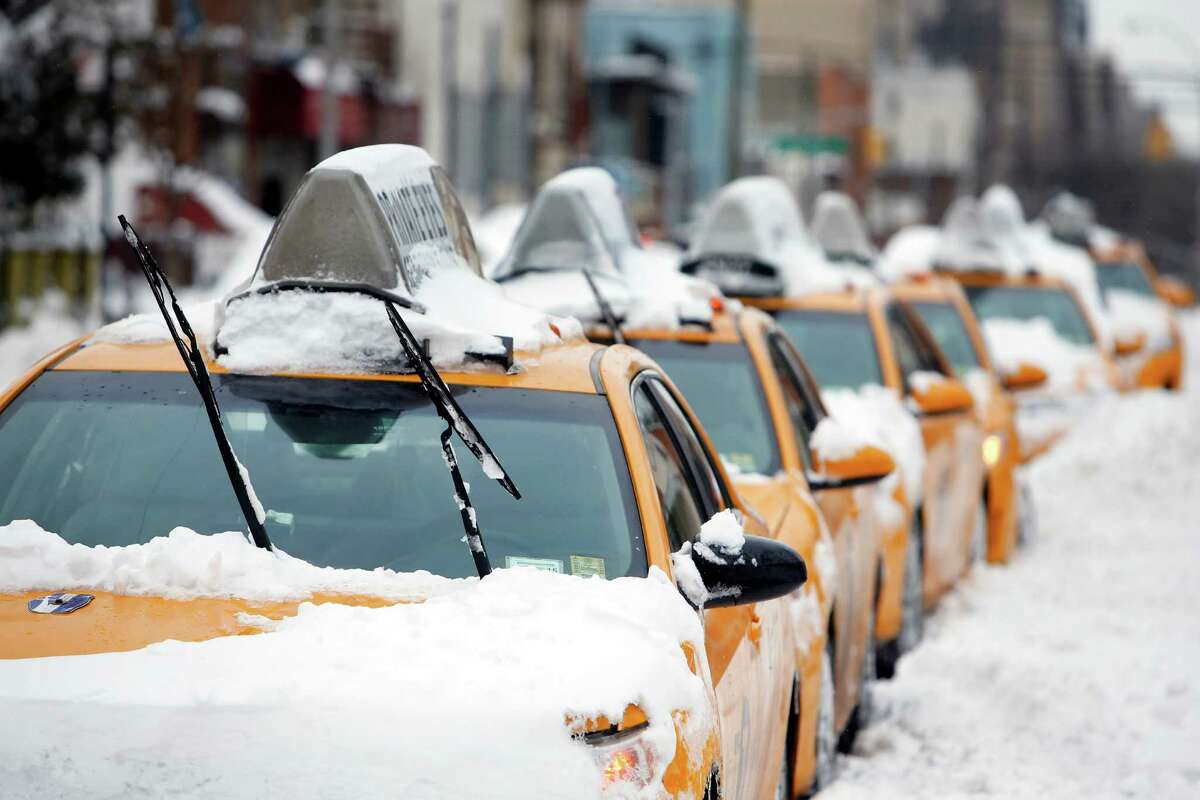 Taxis that belong to Arthur Cab Leasing Corp., stand idle outside the company's lot before being put it back into service following a winter storm, Tuesday, Jan. 27, 2015, in the Queens borough of New York. Manager Shaon Chowdhury estimates that the winter storm has cost his company approximately $60,000 in lost revenue and added expenses. (AP Photo/Jason DeCrow) ORG XMIT: NYJD113