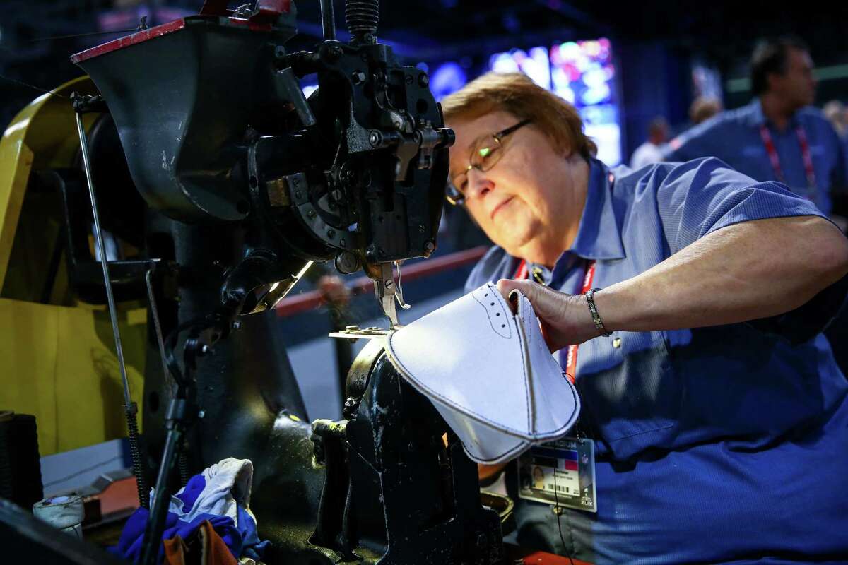 Iva Helser, who worked in the Wilson factory for 48 years, uses an industrial sewing machine to make a football during the NFL Experience on Wednesday, Jan. 28, 2015 in downtown Phoenix. The event is a free, football-themed event for fans. One million visitors are expected to attend Super Bowl-related events in downtown Seattle.