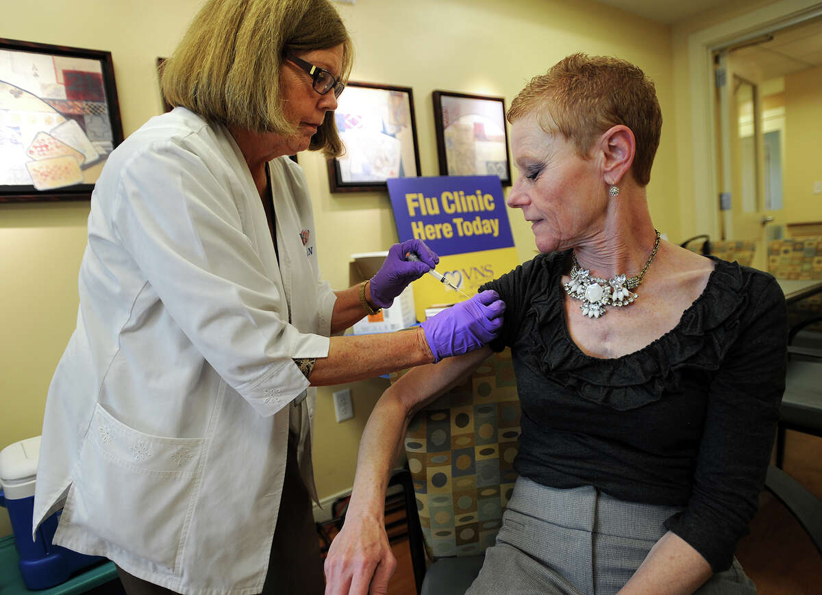 In this file photo, Kathy DelBuono, RN, gives a flu shot to Jane Laufer, of Shelton, during a Visiting Nurse Services of Connecticut public flu clinic at Benchmark Senior Living at Split Rock in Shelton.
