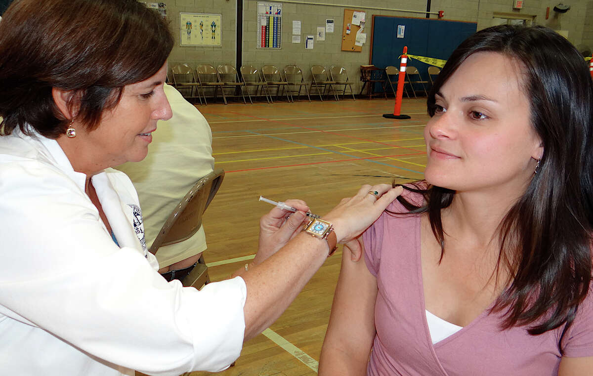 Ariane Balla of Fairfield gets a flu shot from nurse Mary Ellen Dragicevich at a town clinic in the Fairfield Senior Center.
