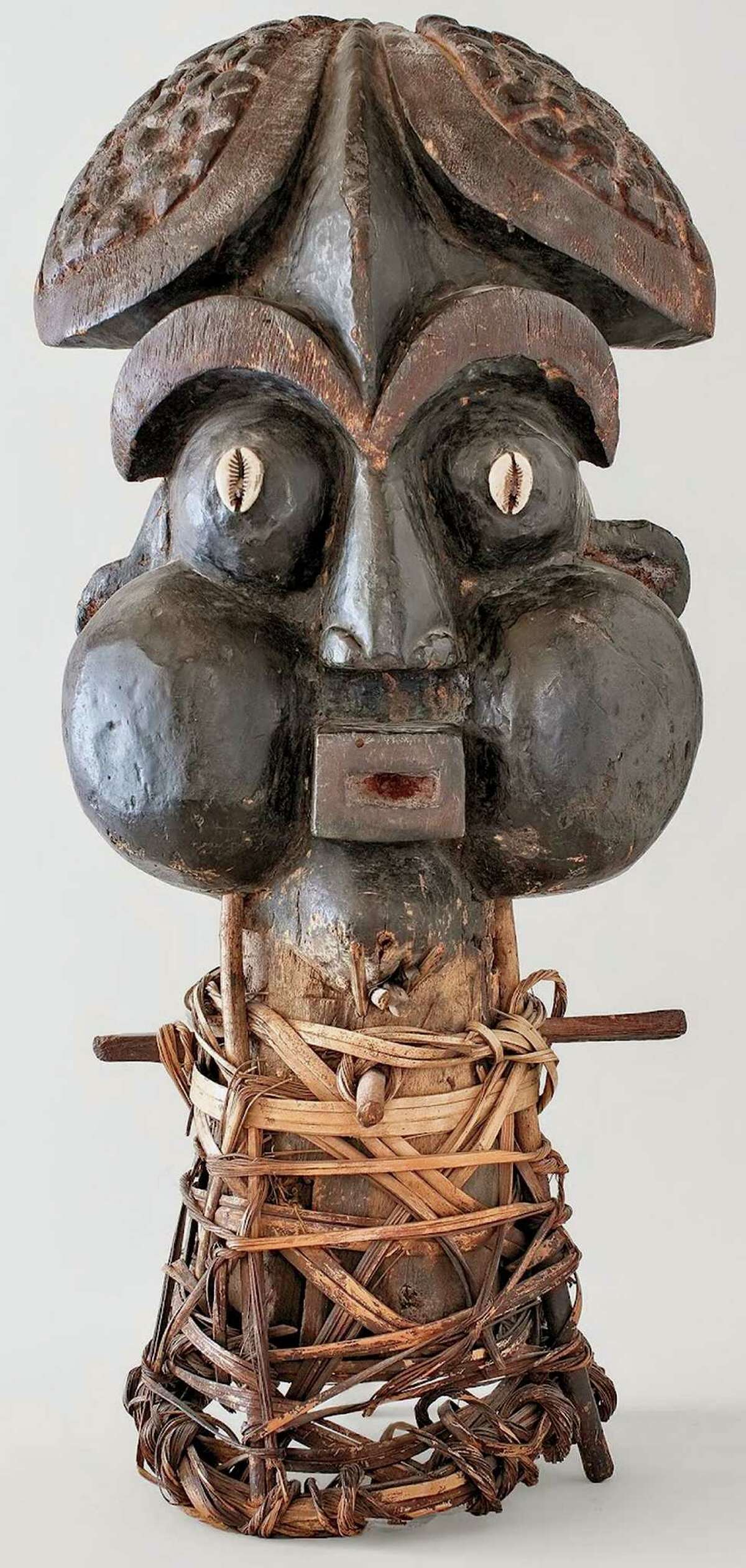 A 20th century Bamum mask from Cameroon, wood, cowries, cane and pigment, at the de Young.