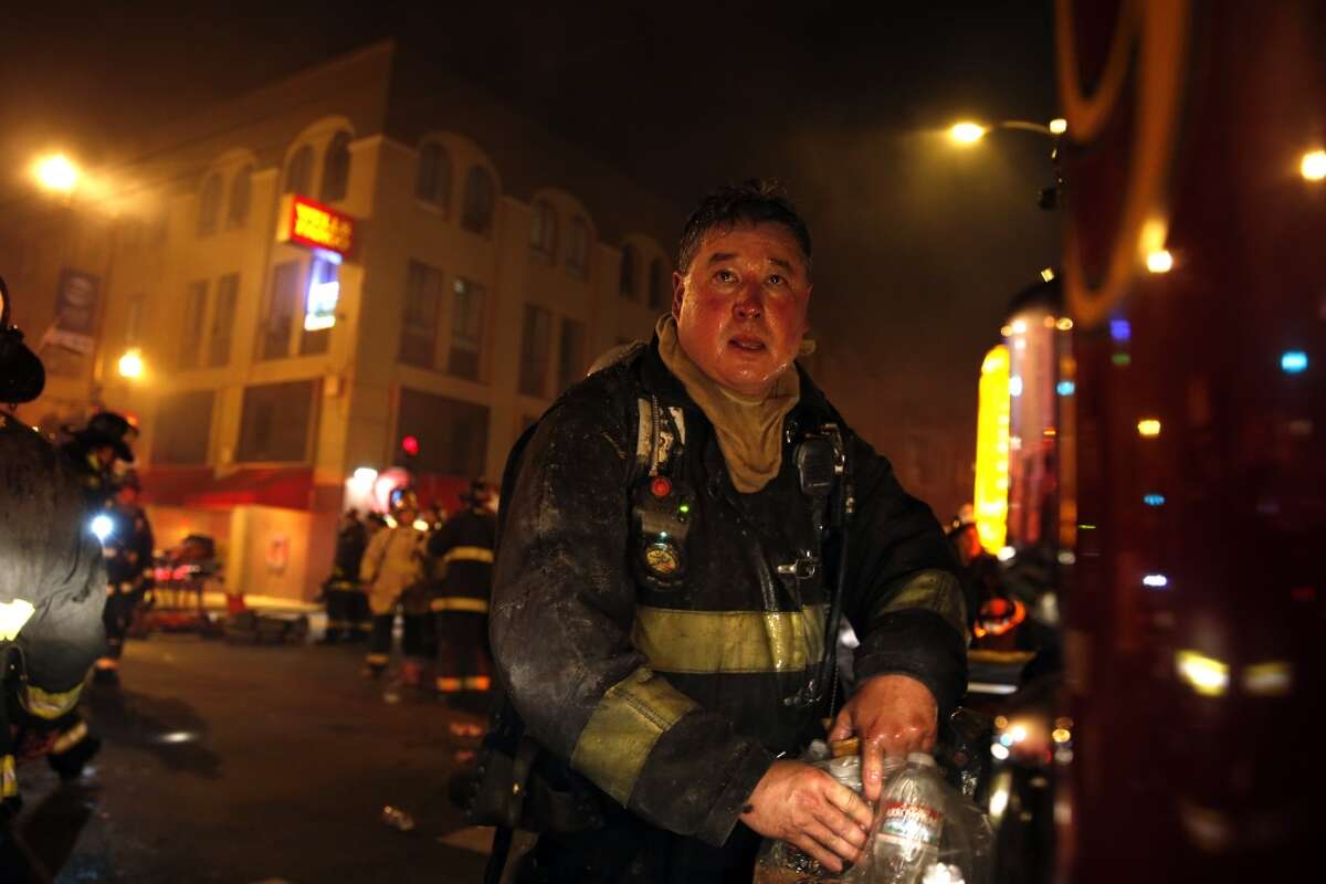 A San Francisco Fire Department member takes a break while fighting a blaze at 22nd and Mission Street in San Francisco, Calif., on Wednesday, January 28, 2015.