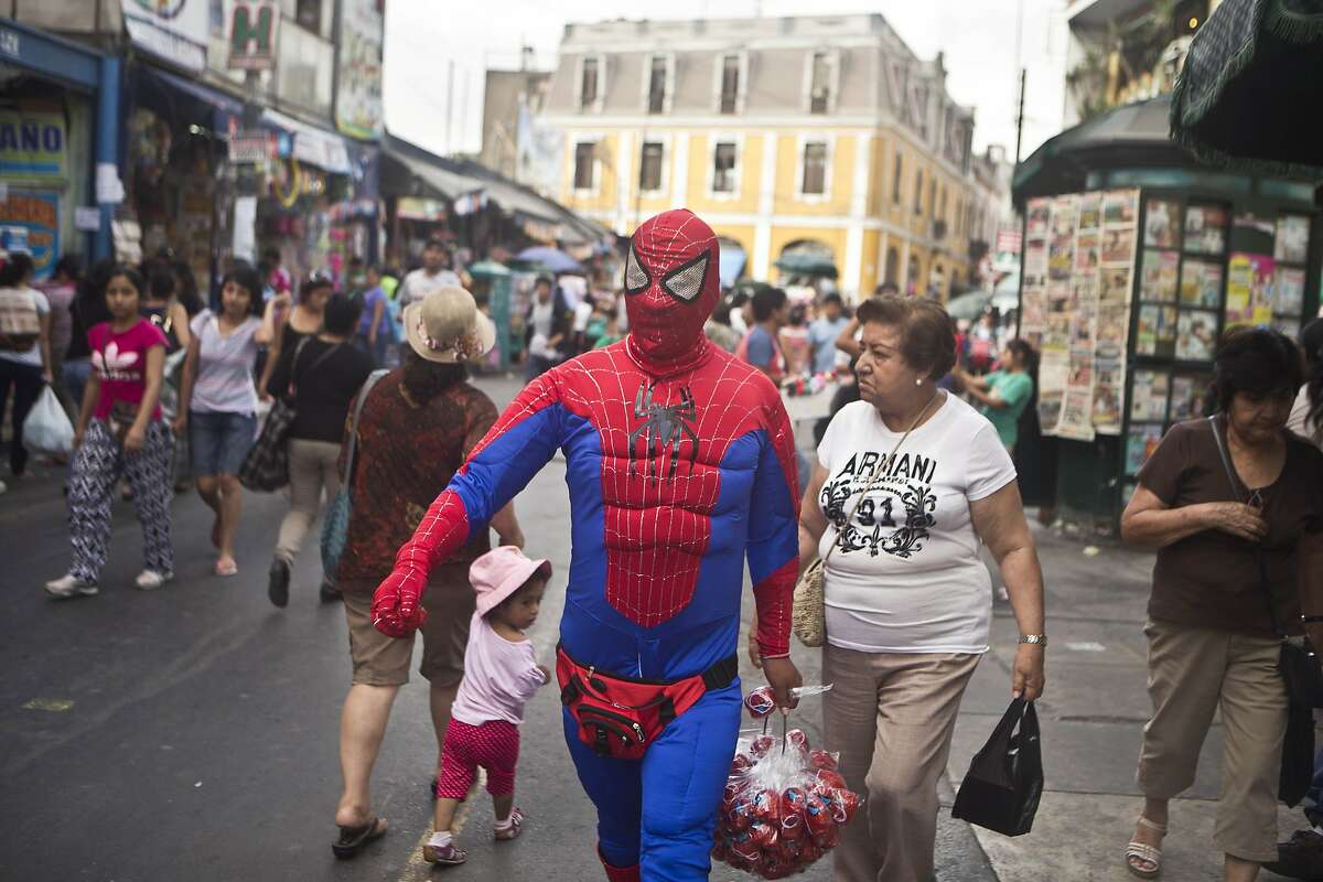 SAY IT AIN'T SO, SPIDEY: Not only is Spider-Man in terrible shape (his abs are where his pecs should be), but he's wearing a fanny pack. Still, he's able to turn a youngster's head in Lima, Peru.