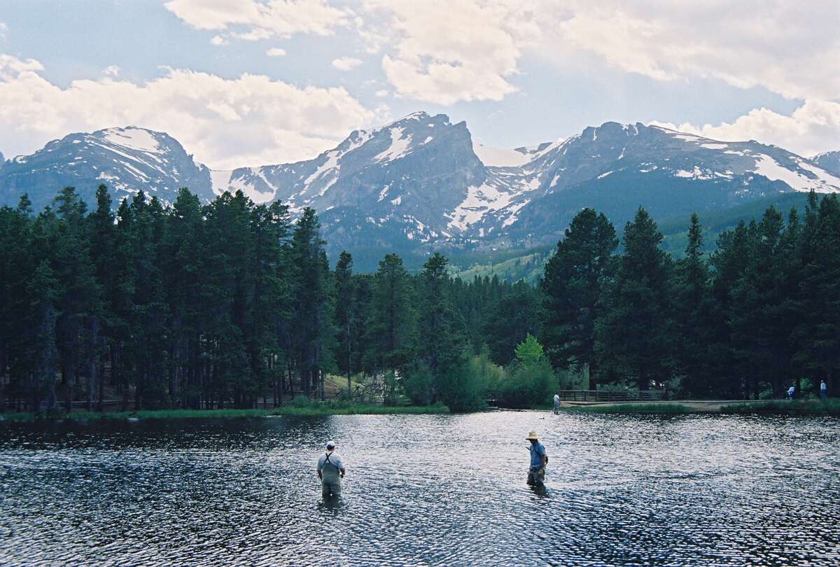A perfect day in the park: Two men outfitted for flyfishing try their luck in the picturesque Sprague Lake in Rocky Mountain National Park.
