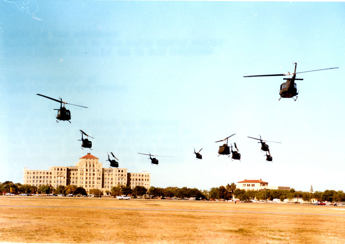 With the original BAMC as a backdrop, Combat Casualty Care Course training participants are flown from Fort Sam Houston to Camp Bullis in 1980.