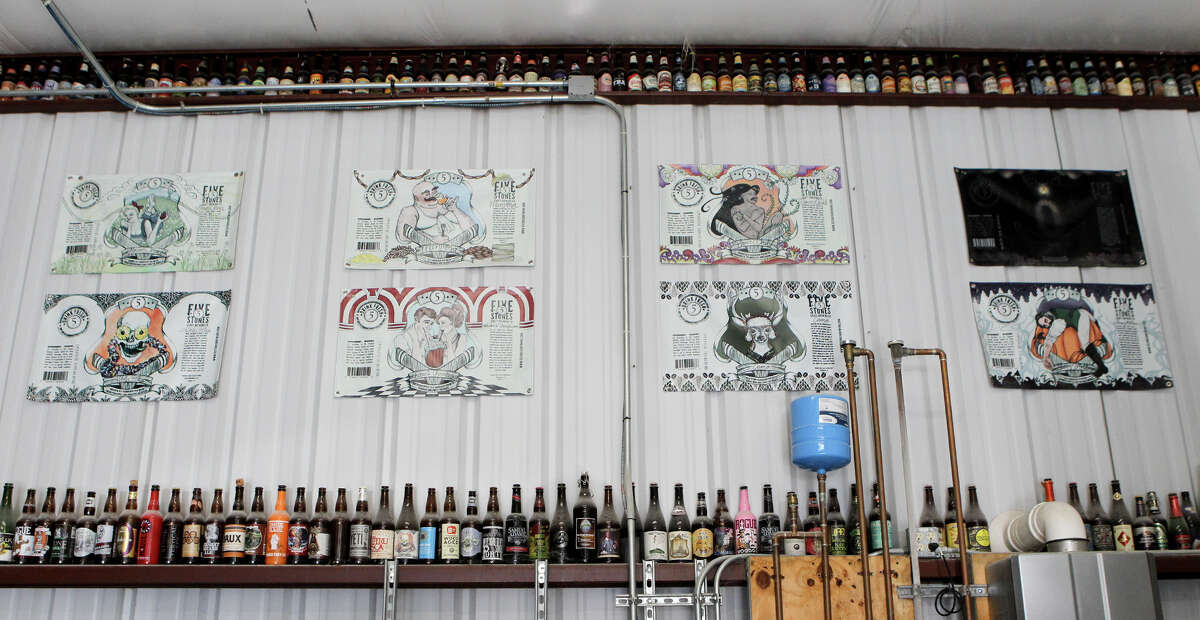 Reproductions of 5 Stones Artisan Brewery's beer bottle labels on the wall at the brewery in Cibolo.