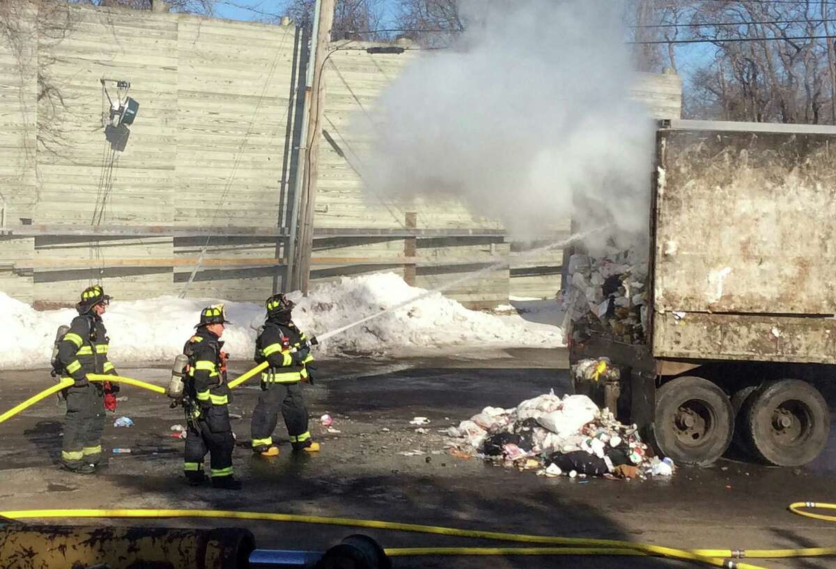 Firefighters battle a fire that erupted in a load of garbage hauled by a tractor-trailer truck on One Rod Highway.