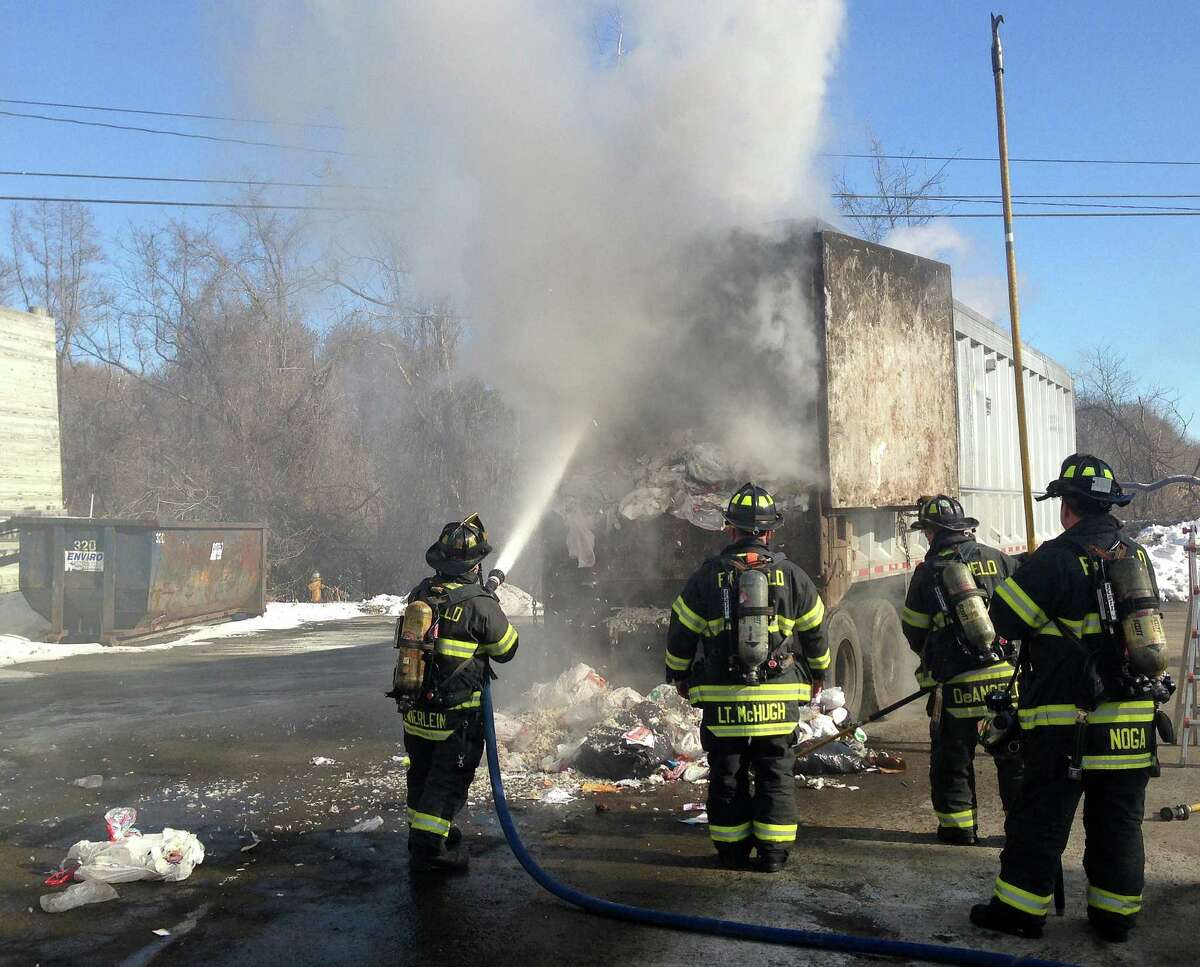 Firefighters battle a smoky fire that erupted in a tractor-trailer truck hauling garbage on One Rod Highway.