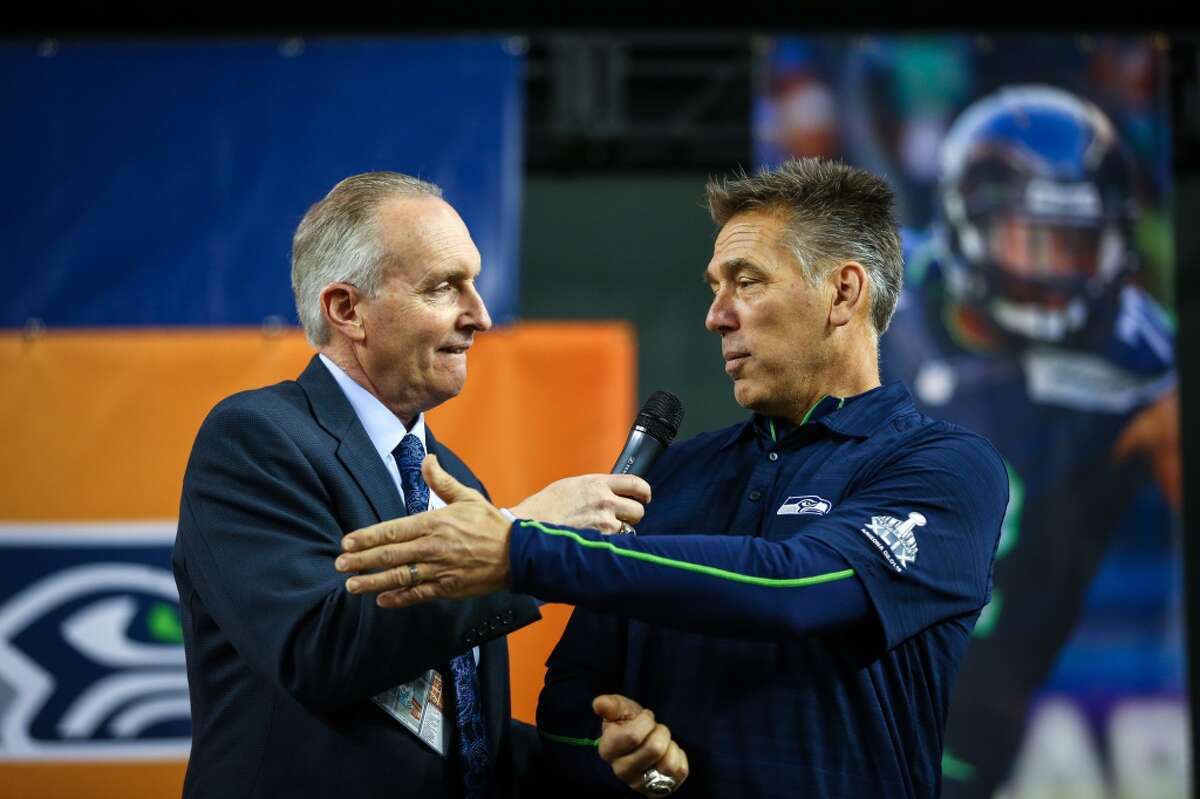 Announcer Steve Raible greets former Seahawks player Jim Zorn on the stage during the Seattle Seahawks Fan Fest at Chase Field in downtown Phoenix. The 12th Man celebration brought tens of thousands of rowdy Seahawks fans downtown, the day before the Seahawks play the New England Patriots in Super Bowl 49. The fan party featured the Sea Gals, Blue Thunder, the team mascots and more. Photographed on Saturday, January 31, 2015. (Joshua Trujillo, seattlepi.com)