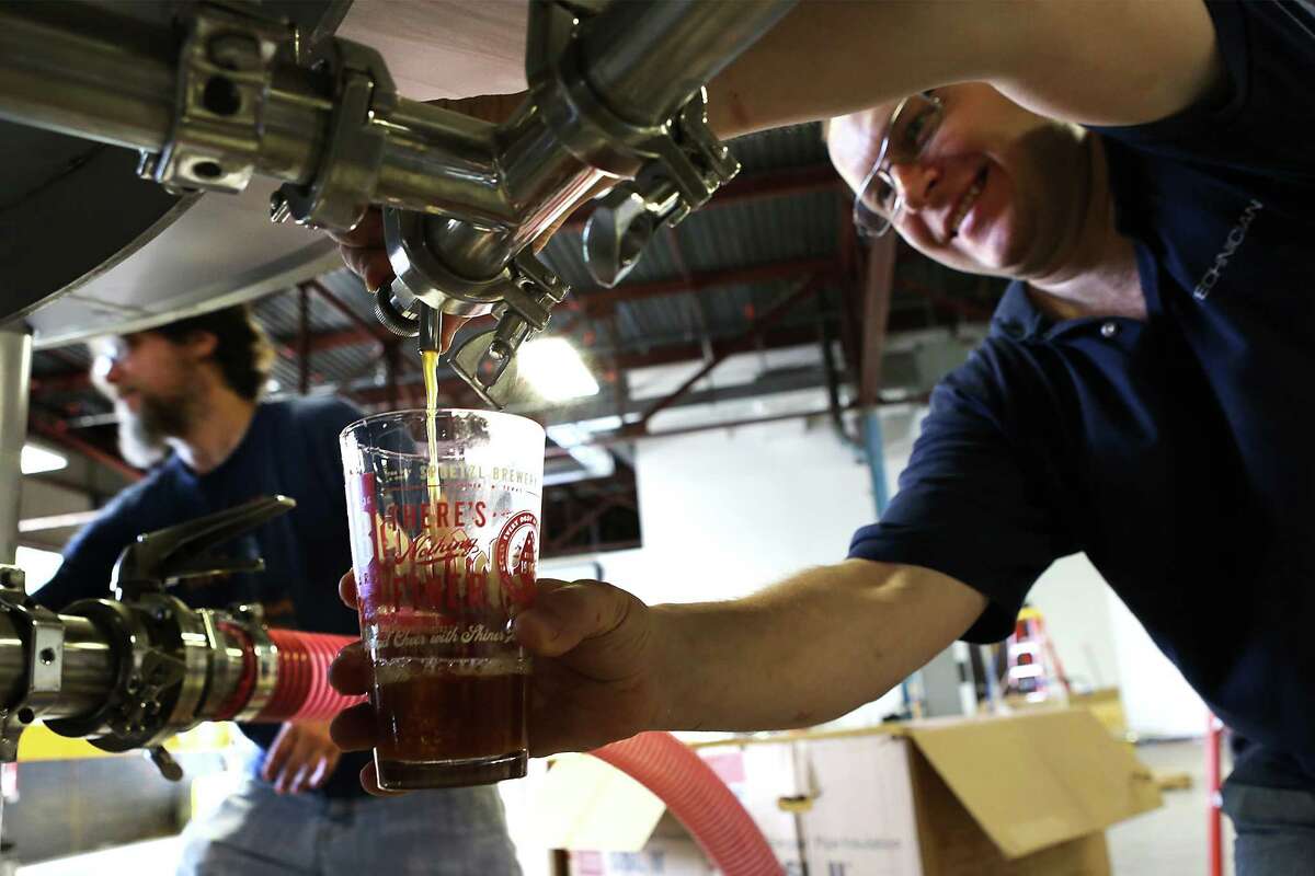 Oleksandr Lyuba, right, fills a glass with wort at Freetail Beer, during the first brewing at the company's second location, on South Presa.