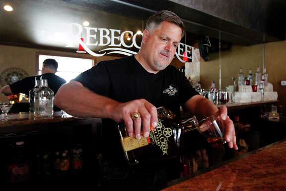 Rebecca Creek Distillery co-owner Mike Cameron pours a sample of whiskey in the tasting room.
