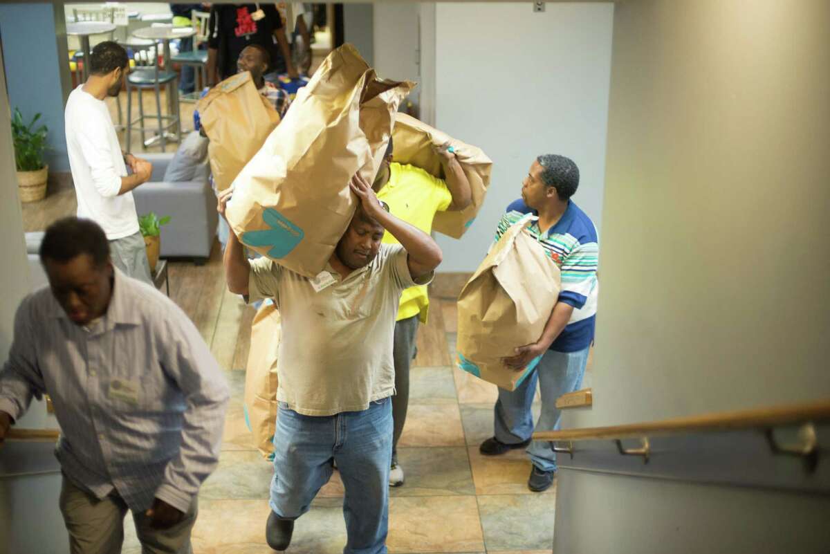 Volunteers bring in large bags of snacks during the Bread of Life﻿ ministry's annual Super Bowl party for the homeless﻿ Sunday.