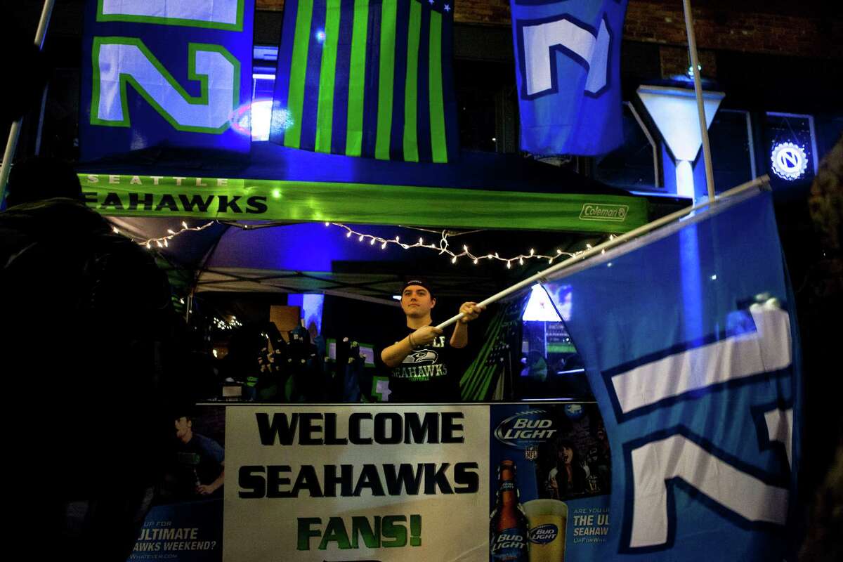 A Seahawks fan waves his 12 flag outside of the Box House Saloon after the Seahawks lost the Super Bowl to the Patriots 28-24.