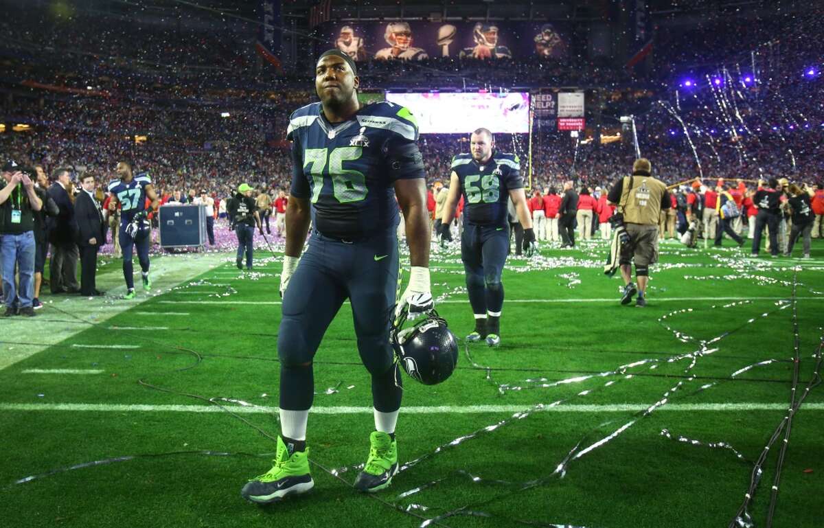 Seahawks player Russell Okung walks off the field with teammates as celebrations begin for the New England Patriots during Super Bowl XLIX at University of Phoenix Stadium. The Seahawks lost to the Patriots 28 to 24. Photographed on Sunday, February 1, 2015. (Joshua Trujillo, seattlepi.com)