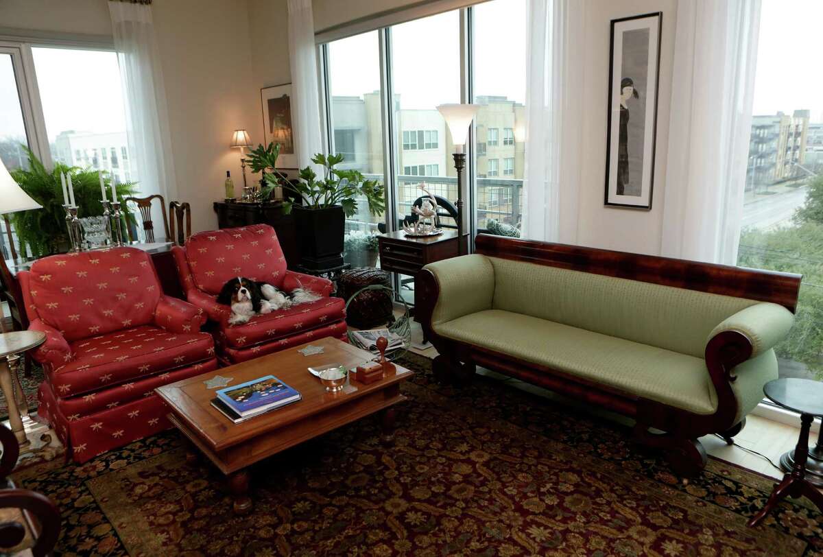 An Empire style sofa, covered in green silk is among the treasures Jill and Bruce MacDougal brought from their home in Monte Vista when the opted for urban living at the Mosaic Apartments on Broadway.