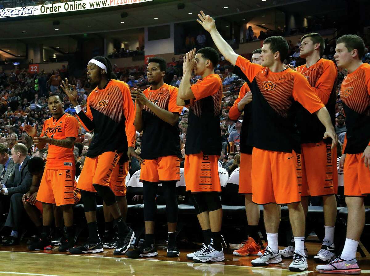 The Oklahoma State bench reacts after a teammate scores a three against the Texas Longhorns at the Frank Erwin Center. The Longhorns dropped their fourth straight game with the 65-63 overtime loss.