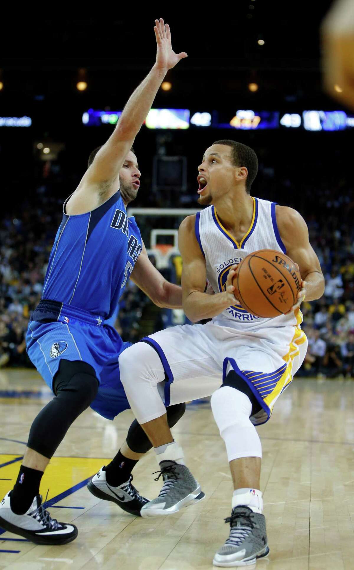 Golden State Warriors' Stephen Curry looks to score against Dallas Mavericks' Jose Juan Barea in 2nd quarter during NBA game at Oracle Arena in Oakland, Calif. on Wednesday, February 4, 2015.