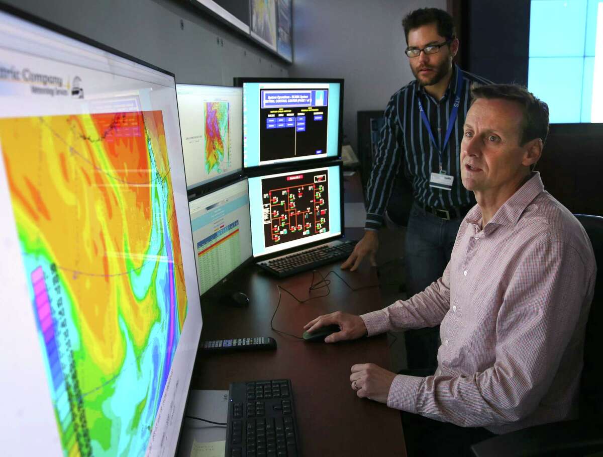 Meteorologists Scott Strenfel (left) and Mike Voss monitor a satellite image depicting an atmospheric river of water vapor approaching the Bay Area at the PG&E Technology Center in San Ramon. PG&E meteorologists use the forecasts to help the utility determine deployment of its repair crews ahead of the storm.