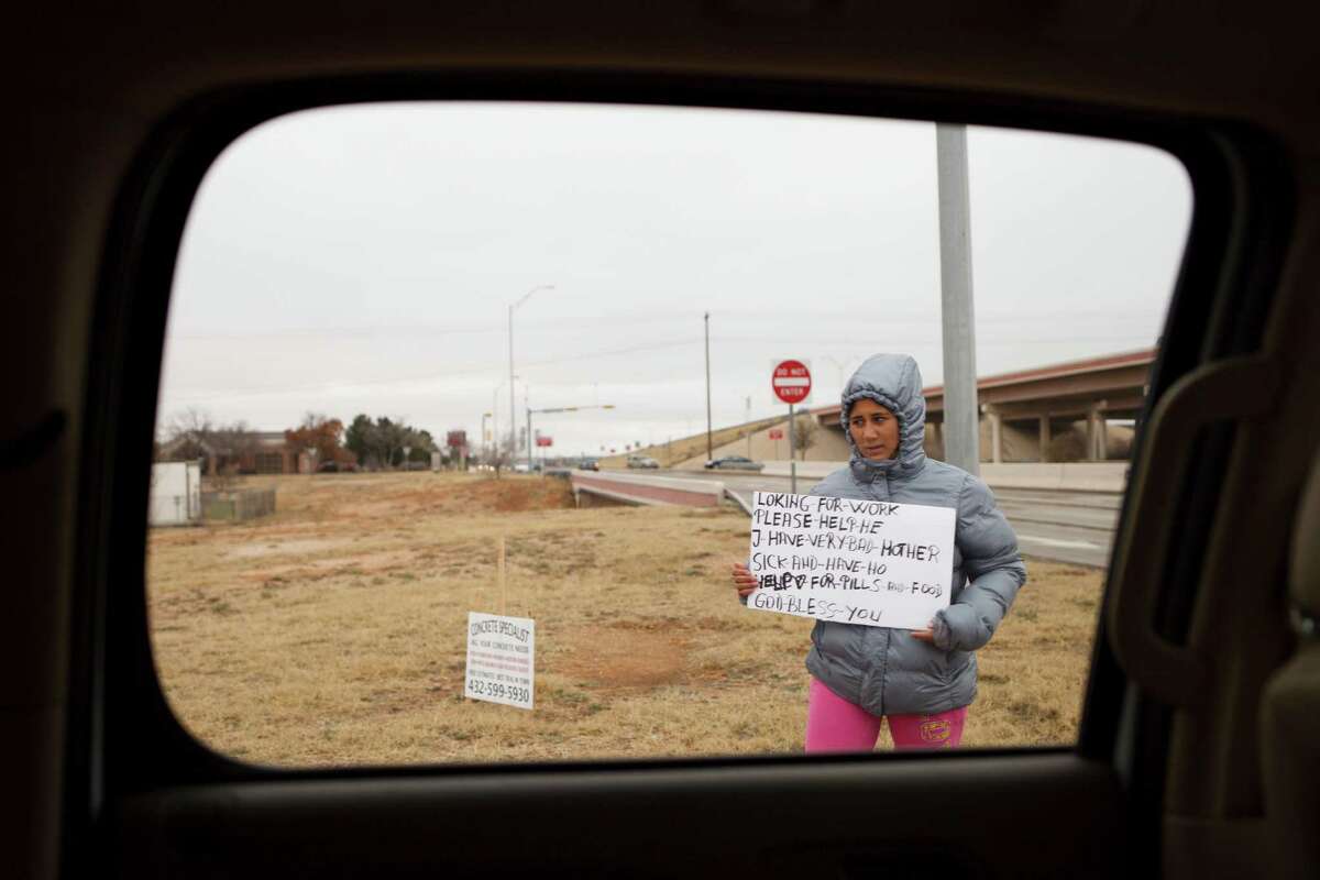 Plunging oil prices could spell economic distress in some quarters. A women begs on the side of the road in Midland, Texas, Jan. 14, 2015. With oil prices plummeting by more than 50 percent since June, the gleeful mood of recent years has turned glum here in West Texas as the frenzy of shale oil drilling has come to a screeching halt.