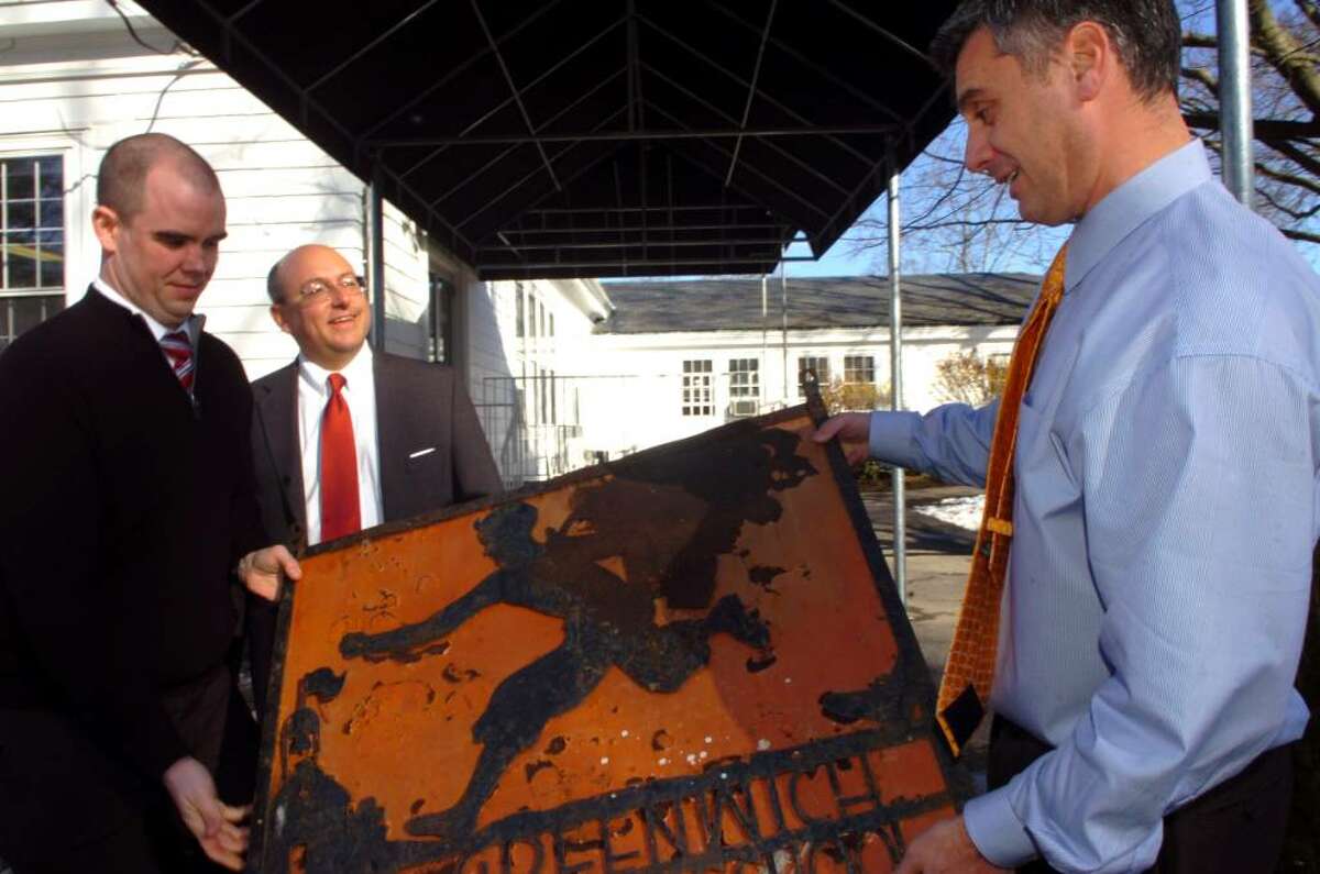 Adam Rohdie, at right, headmaster of Greenwich Country Day School, admires a sign that was taken from the school in 1967. An anonymous client of Attorney Phil Russell's took the sign in 1967 and Russell, center is returning it all these years later, on Monday, March, 1, 2010. At left is John Stewart, an associate of Russell, who graduated from Greenwich Country Day School.