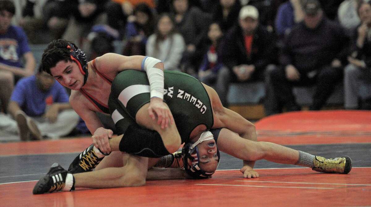 New Milford's Mel Ortiz, bottom, and Danbury's Chris Sam wrestle in the 113 pound weight class during the high school wrestling match between New Milford and Danbury high schools on Friday night, February 6, 2015, at Danbury High School, Danbury, Conn.