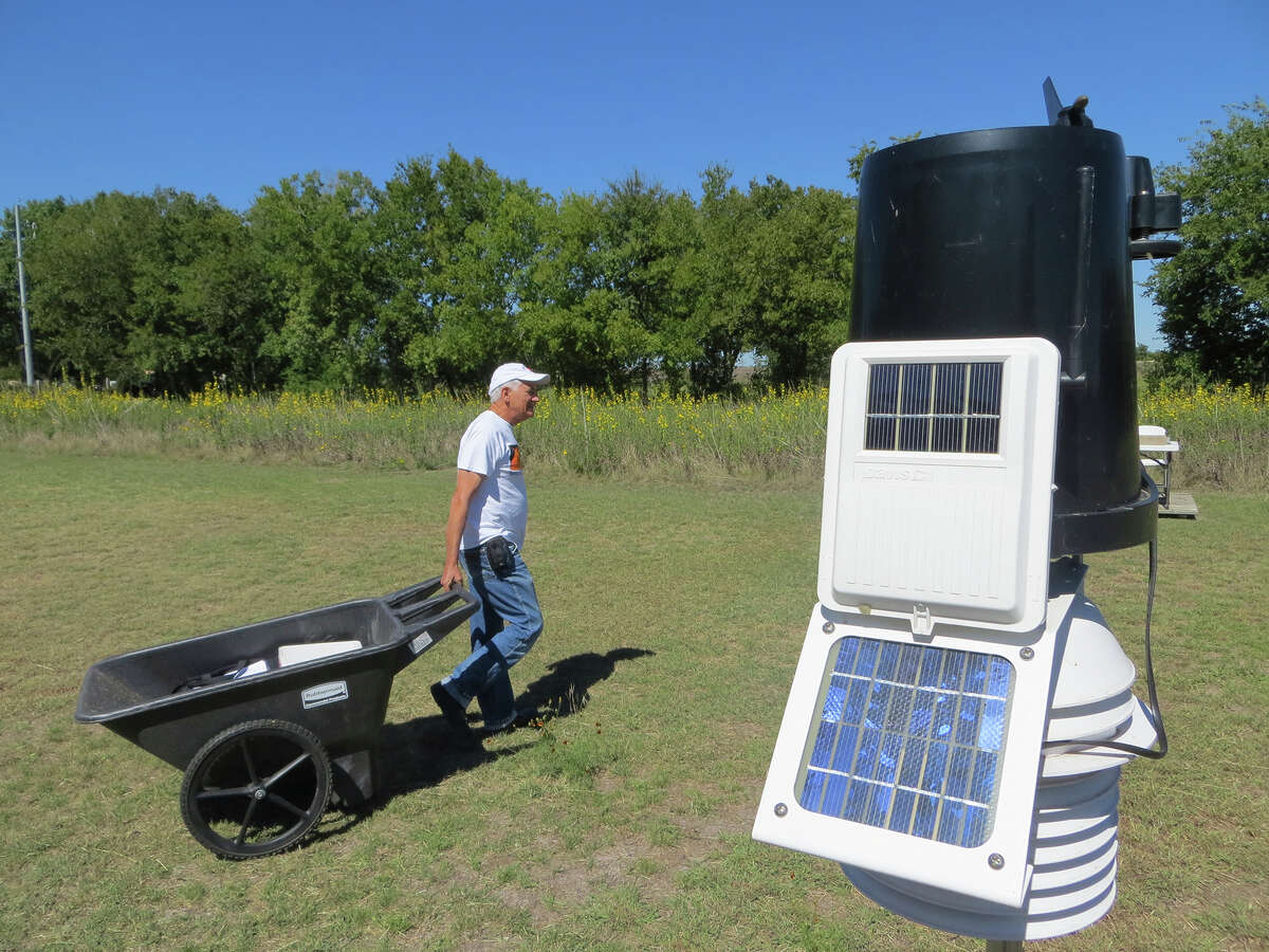 Forrest Mims III uses a garden cart to haul instruments packed in coolers to a small table in the field beside his Seguin home, which he calls “The Geronimo Creek Observatory,” where he has recorded climate data on nearly a daily basis since Feb. 5, 1990. An automated weather station is in the foreground.