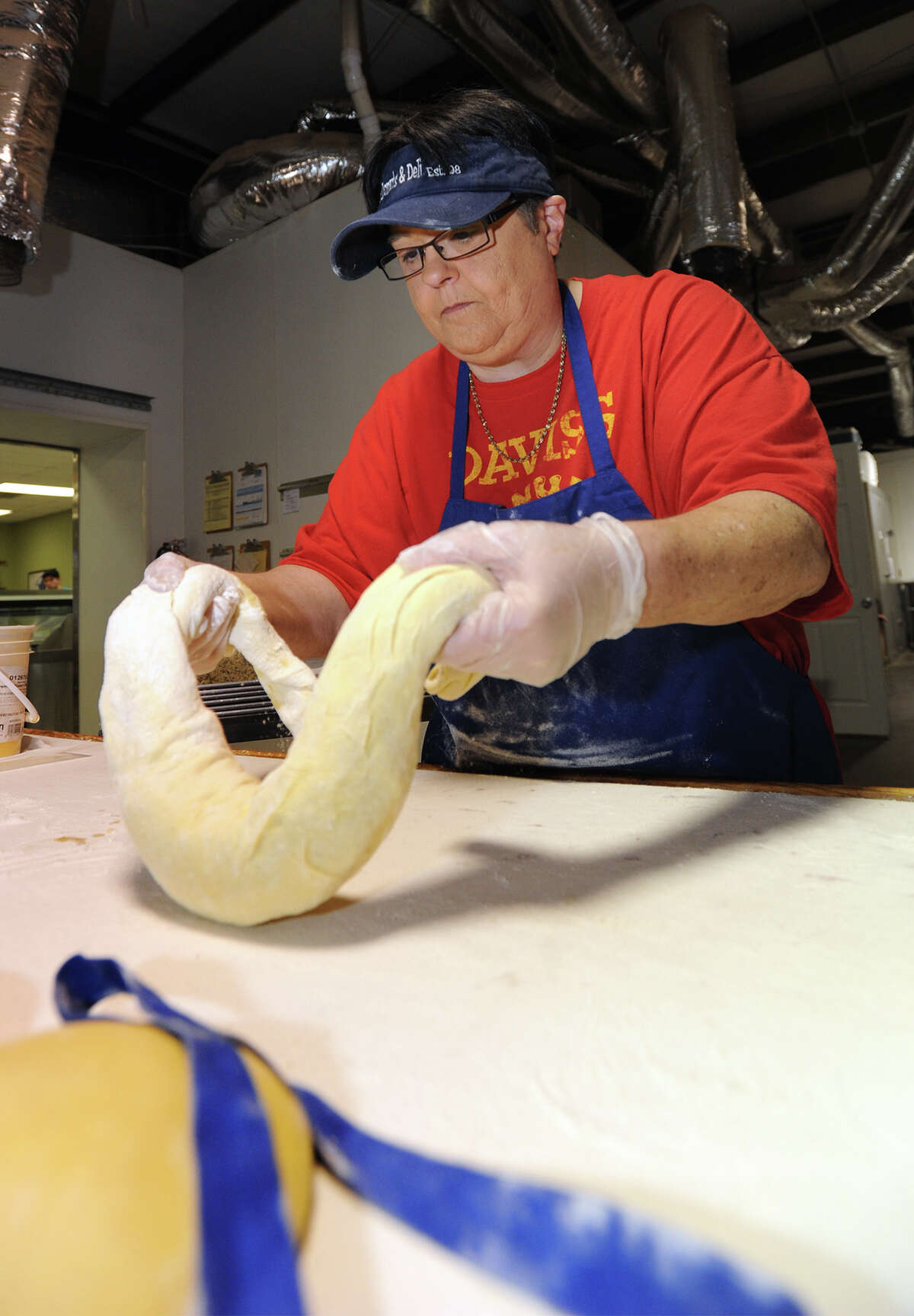 Tracey Beckcom prepares a boudin king cake at Daviss Donuts in Nederland on Wednesday. Beckcom uses a traditional dough then adds boudin, cheese and a bacony syrup topping. Beckcom added that she has made around 60 boudin cakes this year. Photo taken Wednesday, February 04, 2015 Guiseppe Barranco/The Enterprise