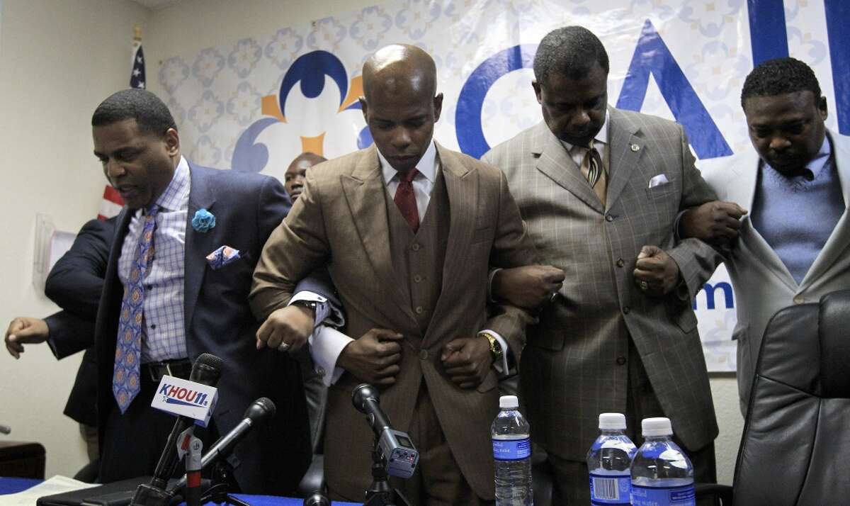Activist/Advocate Deric Muhammad, center, prays with Pastor E.A. Deckard, left, and Minister Robert Muhammad, right. Continue clicking to see the police abuse videos that have gone viral over the years.