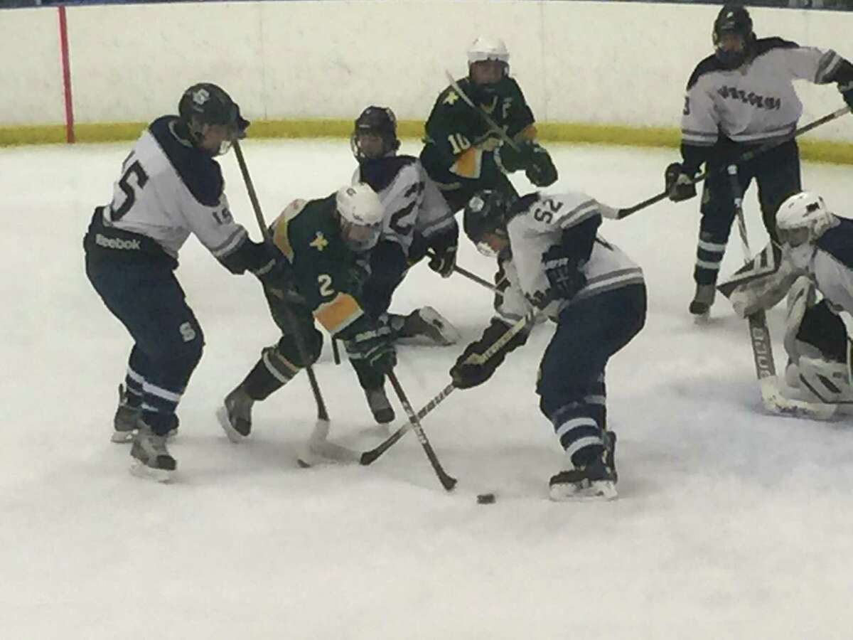 Trinity Catholic freshman Kyle Bernard, center, tries to get a shot off while surrounded by Staples defenders Robert Wehmhoff, left, and Sam Zaritsky, right during a game on Tuesday. Staples co-op won 7-1.