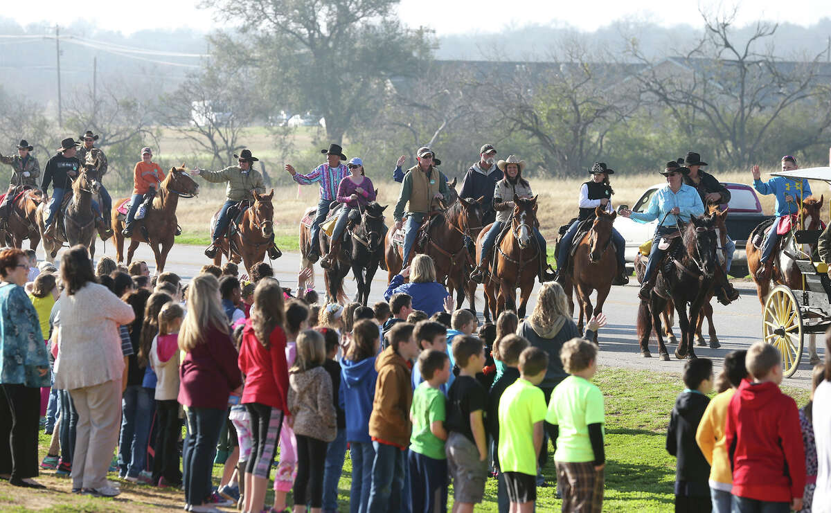Students at La Vernia Primary and Intermediate schools watch the riders from their school grounds as the Old Chisolm Trail Riders start off from the La Vernia City Park early on Wednesday, February 11, 2015 , heading into San Antonio on Texas 87.