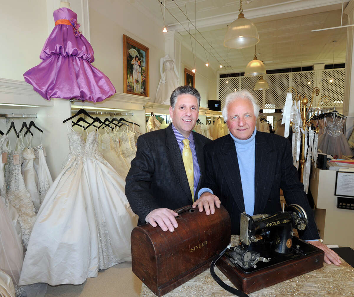 At left, Cory Fontana, owner of the Fontana Bridal Salon at 45 E. Putnam Ave., in Greenwich, Conn., Wednesday, Feb. 11, 2015, stands with his father, Frank Fontana, in the salon that will be celebrating its 70th anniversary on Valentine's Day. Frank's mother, Anita Fontana, was the salon's founder, the pair are posed with the Singer sewing machine that Anita used to start her business.