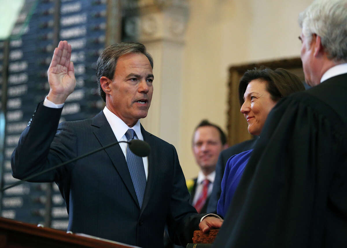 Joe Straus takes the oath of office as Speaker of the House with his wife Julie holding the family Bible during the opening of the 2015 Legislature at the State Capitol on January 13, 2015.
