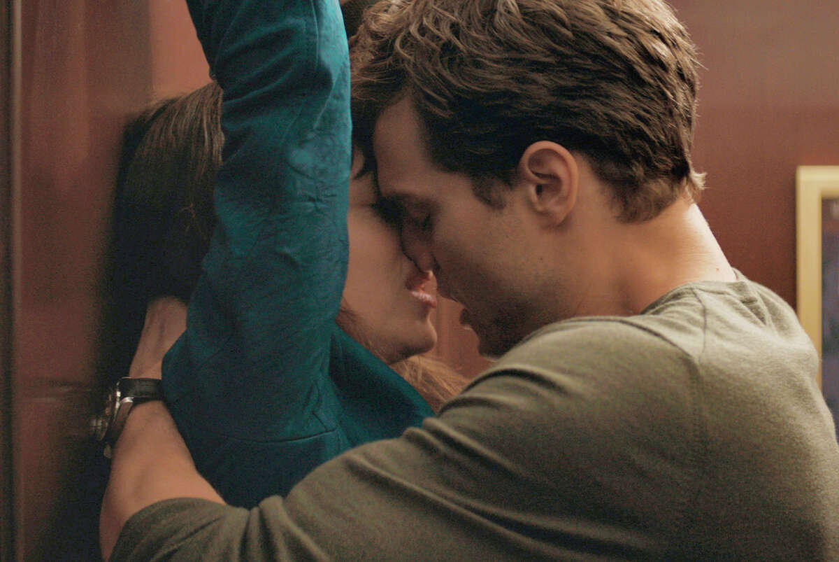 Dakota Johnson (left) and Jamie Dornan have a close encounter in the erotic phenomenon “Fifty Shades of Grey.”