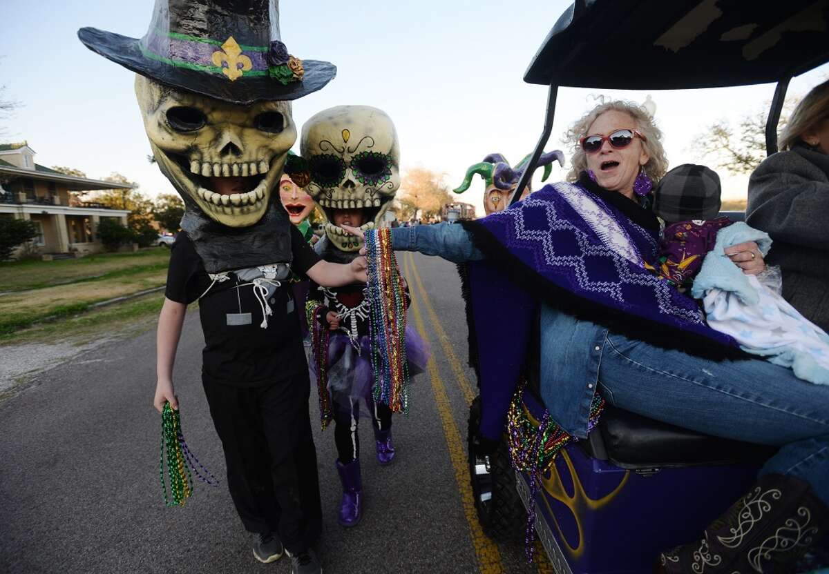 Nancy Working, right, replenishes the bead supplies of Trevor Kimbell, 13, and Kailey Chileress, 15, during Thursday afternoon's parade. Port Arthur held the Courir du Mardi Gras Parade along Lakeshore Drive on Thursday night. The small parade acts as one of the opening ceremonies of Mardi Gras in the city. Photo taken Thursday, 2/27/14 Jake Daniels/@JakeD_in_SETX