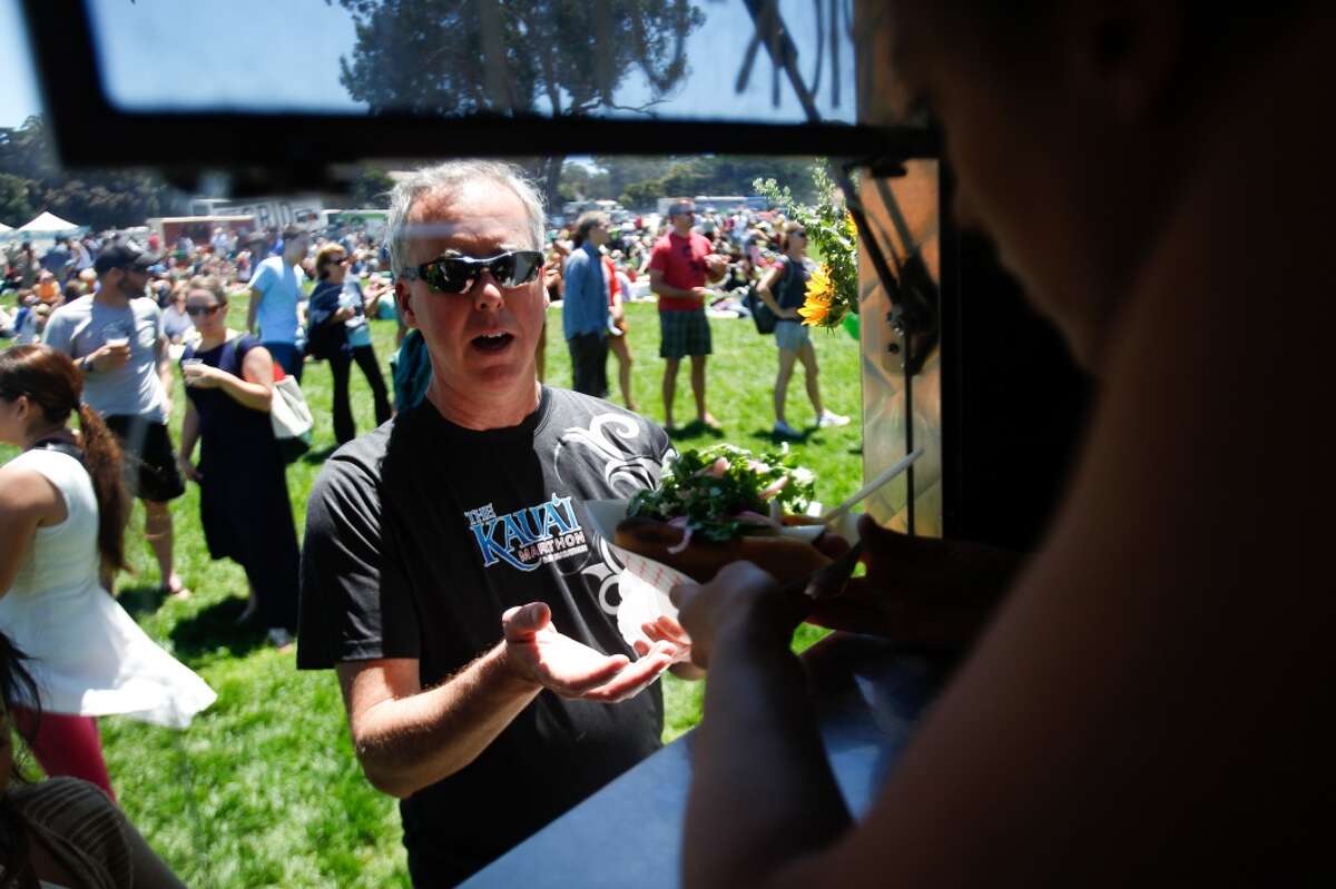 Ian McNicholl receives his order from Fins on the Hoof at Off the Grid Sunday picnic at the Main Post of the Presidio in San Francisco.