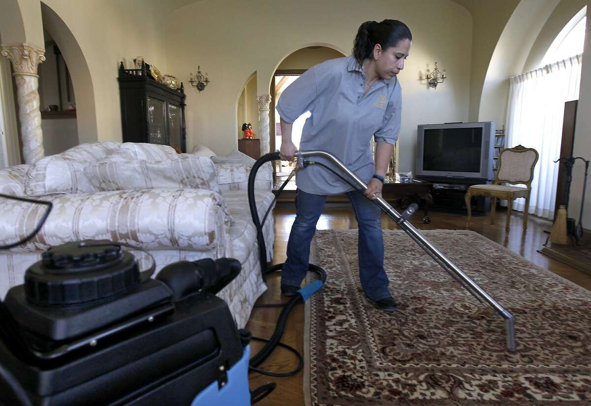 Rosa Sanchez, of Homejoy, steam cleans a rug for Rie Yamazaki-Bach in San Francisco, Calif. on Tuesday, Oct. 28, 2014. Many homeowners are turning to Homejoy to connect with maintenance services such as carpet cleaning, plumbing and painting.